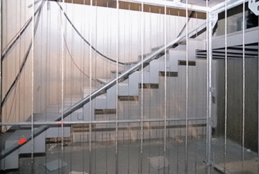 Obr. 10a: Zábradlí schodiště je zavěšeno na 5mm lankách (jachtařského typu). Kmitání zábradlí způsobí poruchy upevnění uložení. Nosníkový model schodnic není vhodný, nezbytná je stěnová napjatost.