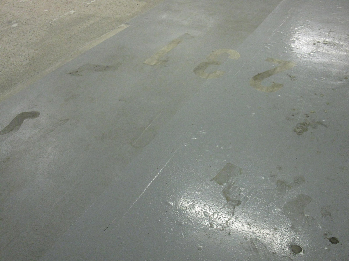 Obr. 1: Epoxidová povrchová úprava v nejnižším suterénním podlaží parkovacích garáží, postižená vznikem „puchýřů“