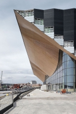 Centrum múzických umění Kilden v Norsku tvoří ocelová konstrukce se zvlněnou dubovou fasádou, která prochází od moře do interiéru budovy