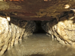 Obr. 13, 14 a 15: Odvod vody kanálkem v jílové vrstvě pod podlahou, patrná vlhčí podlaha v místě trasy kanálku