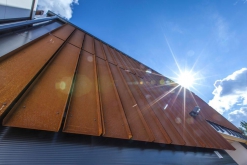 Část budovy s fasádou ze samopatinující oceli Cor-Ten. Šikmá střecha je z krytiny Ruukki Classic s plně integrovaným solárním systémem pro ohřev vody (Ruukki Classic Solar).