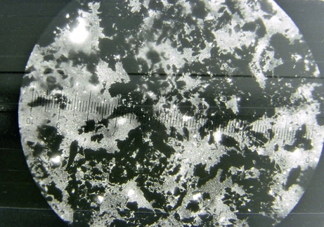 Obr. 6: Reakce asfaltu s dehtem pod mikroskopem. Vysrážený uhlík.